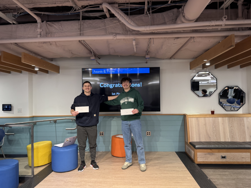 Winners, Zefan Nathanson and Lev Shayman, stand on stage with their money award.